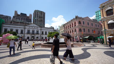 Tiro-Inclinado-De-Personas-Pasando-La-Fuente,-En-La-Plaza-Del-Senado,-En-Macao