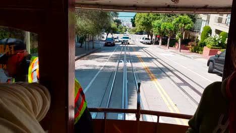 View-from-back-of-SF-Cable-Car-while-riding-and-going-up-the-hill-with-Ambulance-following-in-San-Francisco,-California,-USA