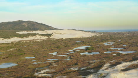 Aerial-view-of-sand-dunes-and-lagoons,-Praia-Da-Joaquina,-Florianopolis-city,-Santa-Catarina,-Brazil