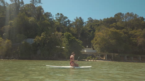 female-tourist-paddles-through-the-ocean-off-Borneo-on-stand-up-paddleboard