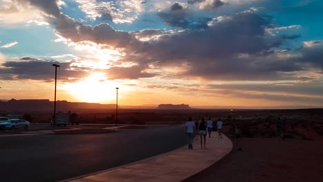 360-degree-sunset-panning-shot-showing-tourists-at-lookout-point-of-panorama-at-Monument-Valley,-Arizona,-USA