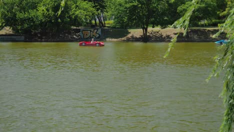 Városligeti-Seestadtpark,-Mehr-Leute-Auf-Tretbooten-Vorbeifahrend