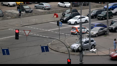 Belebte-Kreuzung-In-Einer-Großstadt-Mit-Vielen-Autos,-Die-An-Einer-Roten-Ampel-Geparkt-Sind,-Und-Anderen,-Die-Die-Straße-An-Einer-Grünen-Ampel-überqueren