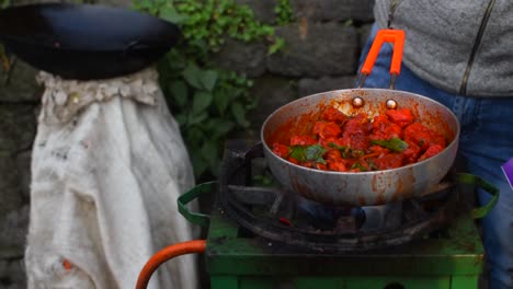 A-slow-motion-shot-of-a-street-vendor-pouring-Coriander-leaves-in-the-sauce-pan-with-Chicken-for-making-Chilly-Chicken-and-sell-it-in-the-streets-of-Darjeeling