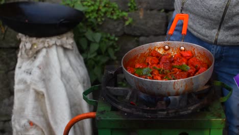 Eine-Zeitlupenaufnahme-Eines-Straßenhändlers,-Der-Korianderblätter-In-Die-Saucenpfanne-Mit-Hühnchen-Gießt,-Um-Kühles-Hühnchen-Zuzubereiten-Und-Es-In-Den-Straßen-Von-Darjeeling-Zu-Verkaufen