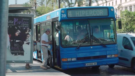 La-Tercera-Edad-Se-Sube-Al-Autobús-Azul-De-La-Ciudad-En-Jerez,-España,-Cámara-Lenta