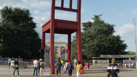 Geneva,-Switzerland---Tourist-taking-picture-and-passerby-at-the-United-nation-chair-monument---Orbit-shot