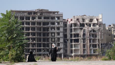 Zwei-Frauen,-Die-Hijabs-In-Homs-City-Tragen,-Ruinierten-Riesiges-Gebäude-Auf-Der-Rückseite