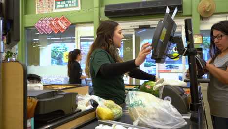 Amable-Cajero-En-El-Mercado-De-Agricultores-De-Brotes-En-Chula-Vista,-California,-Charlando-Con-Un-Cliente