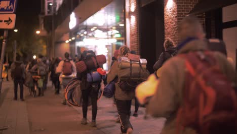 Menschen,-Die-Taschen-Und-Campingausrüstung-Tragen,-Gehen-Nachts,-Am-Frühen-Morgen,-Während-Der-Klimaproteste-Von-Freiwilligen-Der-Extinktionsrebellion-Durch-Die-Straßen-Von-Amsterdam