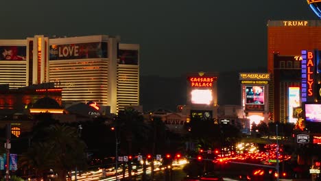 Puesta-De-Sol-En-La-Franja-De-Las-Vegas,-Lapso-De-Tiempo-Del-Tráfico-Del-Bulevar,-Hotel-Trump-Y-Mirage-Y-Castino-E-Iluminación-Colorida-De-La-Ciudad