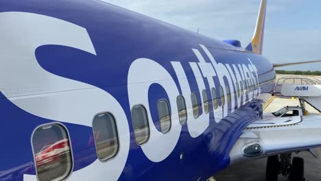 Mujer-Con-Largo-Cabello-Castaño-Oscuro-Hace-Cola-Para-Abordar-Un-Avión-De-Southwest-Airlines