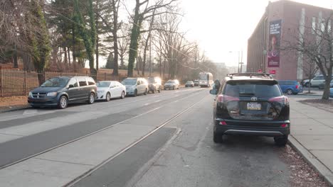 Trolley-passes-camera-along-Woodland-Avenue,-West-Philadelphia