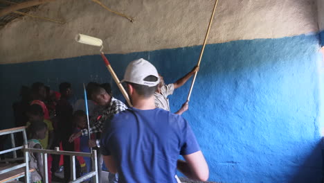 Grupo-De-Voluntarios-Locales-Y-Miembros-De-Eventos-De-Caridad-Pintando-Dentro-De-La-Pared-Del-Aula-De-La-Escuela-En-Ziway,-Etiopía