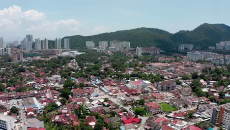 Full-city-view-with-Kek-Lok-Si-Buddhist-temple-to-the-right-after-camera-motion,-Aerial-drone-pan-right-shot