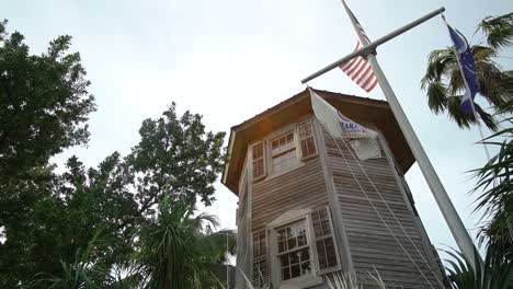 Old-Caribbean-House-With-Nautical-Flagpole-in-Front-On-a-Cloudy-Day-Pan-Left