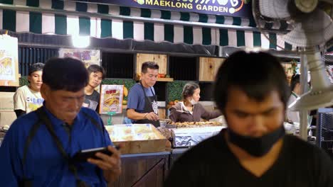Gruppe-Von-Leuten,-Die-An-Einem-Straßenlebensmittelstand-Arbeiten,-Nachtmarkt-Bangkok
