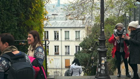 Nov-2019,-Paris,-France:-Asian-tourists-walking-down-one-of-the-small-sloped-alleys-in-Montmartre-district-on-a-cold-Autumn-morning