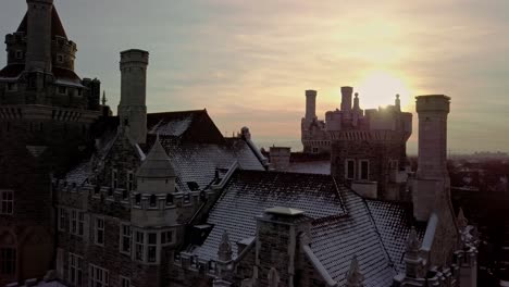 Fresh-Snow-on-the-Towers-and-Chimneys-of-an-Old-Castle,-Aerial-Push-In