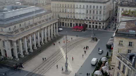 Plaza-Del-Gran-Teatro-De-La-Ópera-Con-Personas,-Vehículos-Y-Vías-De-Tranvía,-Toma-De-Revelación-Del-Pedestal-Aéreo-Que-Se-Levanta