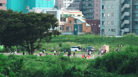 Tamagawa,-Japón-Con-Gente-Jugando-Y-Relajándose-En-Un-Día-Ventoso---Tiro-De-Trípode