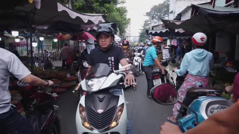 slow-motion-of-chaotic-busy-street-motor-scooter-traffic-in-a-busy-market-street-riding-towards-the-camera