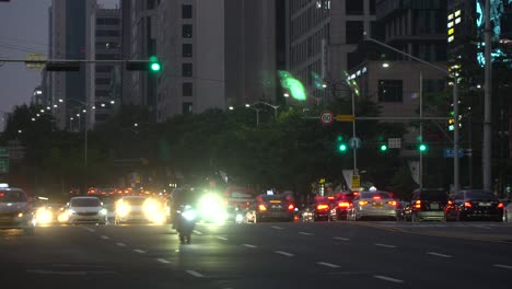 Numerous-cars-and-buses-passing-by-at-a-multilane-crossroads-at-Gangnam-station-on-green-signaling-light,-Seoul,-South-Korea