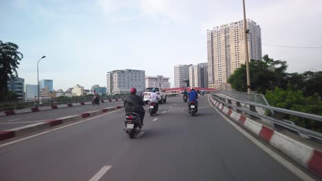 Stabilisierter-Kardanischer-Schuss-Beim-Überqueren-Einer-Großen-Saigon-Brücke-Auf-Einem-Motorrad-Mit-Blick-Auf-Den-Kanal-Und-Die-Kurven-Anderer-Fahrzeuge