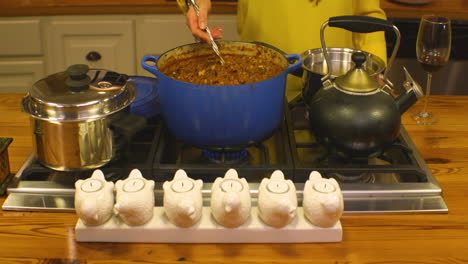 Older-Female-Woman-Stirs-Pot-of-Taco-Soup-with-Spoon,-Close-Up,-Static