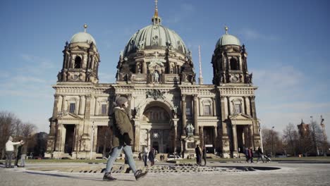 Chica-Caminando-Por-La-Catedral-De-Berlín-Con-Turistas-Parados-Afuera,-Cámara-Lenta