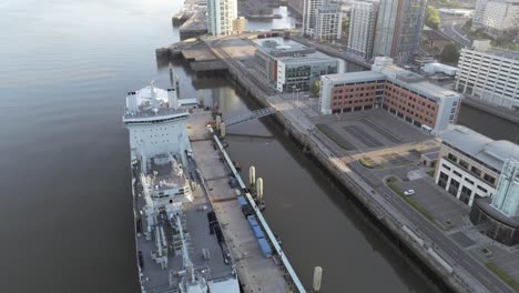 RFA-Navy-Tiderace-military-tanker-on-Liverpool-cityscape-waterfront-at-sunrise-aerial-view-descending