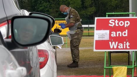 Armeekrankenschwester-Mit-Gesichtsmaske-Testet-öffentlich-Am-Fahrzeugfenster-Im-Unterstand-Des-Corona-Covid-Virus-Center