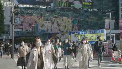 Young-Japanese-Women-Walking-Across-The-Famous-Shibuya-Crossing-With-Go-Signal-Light-At-Background-In-Tokyo,-Japan