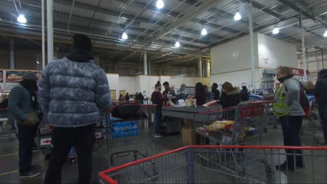 Clientes-Haciendo-Cola-Para-Pagar-Con-Su-Carrito-De-Compras-En-Costco