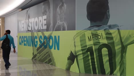 Man-Walking-Across-A-Closed-Store-Inside-A-Shopping-Mall-In-Dubai,-UAE---wide-shot