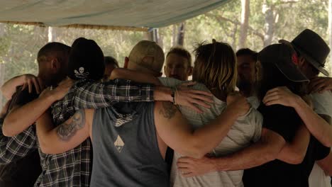 Group-Of-Men-Standing-And-Huddling-In-Circle-Together---Men-Sharing-And-Building-Connection-During-Manhood-Workshop---Queensland,-Australia