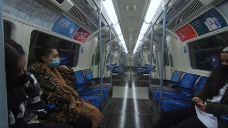 Three-Females-Seated-On-Jubilee-Line-Train-Wearing-Face-Masks-And-Social-Distancing