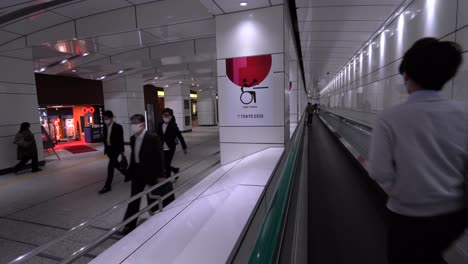 People-with-facemasks-walking-past-Tokyo-Olympic-Games-signs-during-Corona-Pandemic