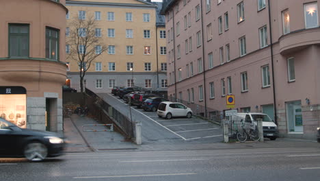 Cars-driving-in-Stockholm-city,-panning-movement-on-a-rainy-day