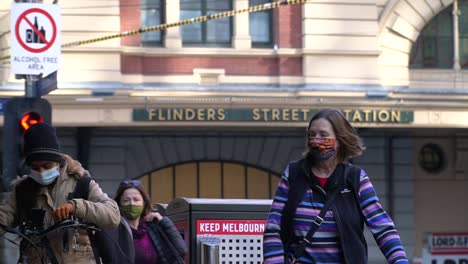 Women-wearing-masks-walk-through-Melbourne's-quiet-streets-during-the-coronavirus-COVID-19-lockdown-restrictions---Victoria,-Australia