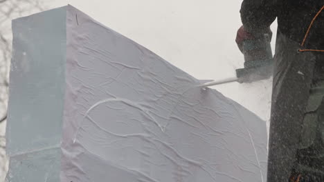 Ice-sculptor-cutting-along-lines-of-template-stuck-to-ice-blocks,-Slow-Motion