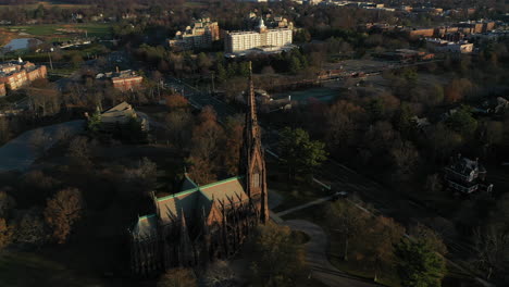 An-aerial-shot-of-a-beautiful-cathedral-with-a-tall-steeple,-taken-at-sunrise