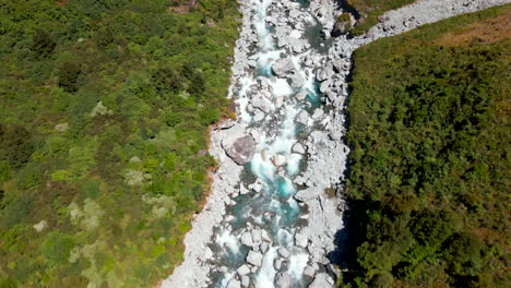 Overhead-view-of-fast-mountain-river-in-rocky-valley-in-Fiordland-Southland,-New-Zealand