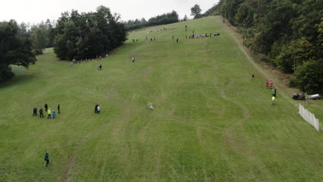 Luftaufnahme-Einer-Person,-Die-Im-Downhill-Grasski-Wettbewerb-Ski-Fährt,-Alpine-Berglandschaft-Im-Sommer