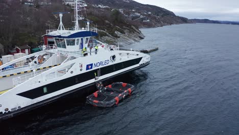 Evacuation-slide-from-ship-to-liferaft-beeing-blown-up-and-made-ready-for-use---Live-training-emergency-liferaft-launch