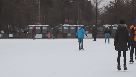 Slomo-Pan-Tiro-Izquierdo-De-Personas-Patinando-Sobre-Hielo-Durante-El-Día