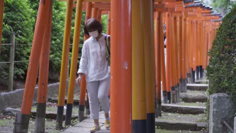 Personas-Con-Mascarillas-Durante-La-Crisis-De-La-Corona-Pasando-Por-Debajo-De-Las-Típicas-Puertas-Torii-Rojas-Japonesas