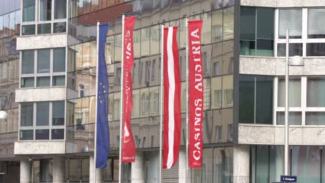 Banderas-De-La-Sede-De-Los-Casinos-De-Austria-Con-El-Logotipo-Frente-Al-Edificio-De-Vidrio