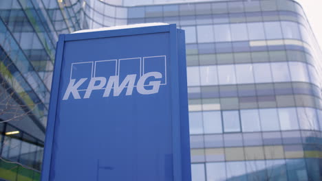 Langsamer-Schwenk-Des-KPMG-Schildes-Vor-Großem-Bürogebäude,-Schnee-Fällt