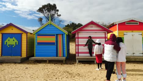 Tourists-walking-and-taking-photo-at-Brighton-Bathing-Boxes,-Melbourne,-Australia